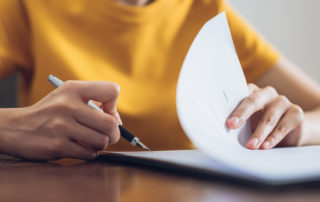 woman signing a ppp loan application