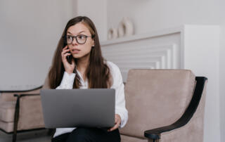 Woman on her phone and using laptop - what happens if a whistleblower is wrong?